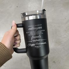 a person holding a black coffee cup with the words happy retirement on it and a straw in their hand