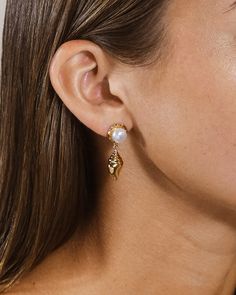 Elevate your style with our Beverly Drops Studs. These exquisite drop earrings feature a delicate combination of shells and pearls, creating a luxurious accessory that will effortlessly elevate any outfit. Make a statement of elegance and sophistication with the Beverly Drops Studs. Material: 14K gold or rhodium plated brass, freshwater pearls Features: 1.2" drop, 0.45" stud, 0.75" charm, 8mm pearls, Lead & Nickel free, post back Elegant Shell-shaped Pearl Earrings, Elegant Shell-shaped Pearl Earrings For Wedding, Shells And Pearls, Solid Gold Bracelet, Solid Gold Earrings, Statement Drop Earrings, Mens Accessories Jewelry, Men Earrings, Pearl Shell