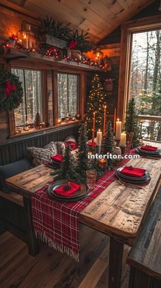 a dining room table set with place settings and christmas decorations on the windowsills