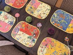 the table is covered with colorful placemats and flowers on it's sides