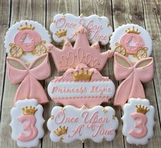 cookies decorated to look like princess crowns and tiaras with pink icing on them