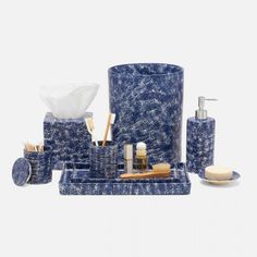 a blue bathroom set with soap, toothbrushes and other items