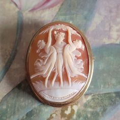 This is a vintage, 14 Karat gold, cameo brooch/pendant, depicting the Three Fates. It is oval and is stamped 14 K and has tested positive for 14 Karat Gold. All sales are final.  Here are the matching earrings: https://www.etsy.com/listing/1590926029/vintage-14-karat-gold-and-carved-shell?click_key=d76dde73ceab74af9a94924aa84797da55a2f746%3A1590926029&click_sum=1122fb90&ref=shop_home_active_6&frs=1&sts=1 The cameo measures 38.5 mm in length, not including the bale. If you have a wish list or are looking for something specific, please ask. I may have exactly what you are looking for. As always please convo me with any questions or concerns regarding this item or with any international shipping questions. Unfortunately I do not accept returns or grant refunds. All shipping fees include handl Oval Intaglio Brooches For Anniversary, Heirloom Oval Brooches With Intaglio, Oval Cameo Brooch For Anniversary, Oval Carved Gold Brooches, Gold Oval Carved Brooches, Heirloom Yellow Gold Cameo Brooches, Ornate Oval Intaglio Brooches, Classic Oval Cameo Brooch, Vintage Cameo Brooch In Yellow Gold