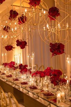 the table is set with red flowers and candles for an elegant wedding reception or special event