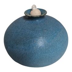 a blue vase with a white ball on top