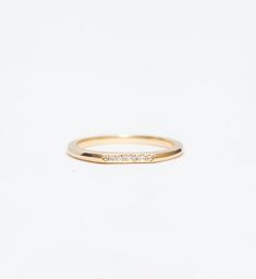 With two faces, this ultra-sleek gold band offers you a beautiful duality. Designed by Bliss Lau to complement her Minimalist Rings, this slender ring features a carefully shaped notch to fit neatly against the solitaire setting. But turn it around and its flat side reveals a glittering pavé of white diamonds, perfect for a sparkling accent to your engagement ring or for subtle brightness on its own. Made in the U.S.A. All sizes available by special order in 4-6 weeks. To inquire, including requ Minimal Wedding Band, Solitaire Setting, Two Faces, Minimalist Rings, Gold Band, White Diamonds, Gold Bands, Diamond White, Wedding Bands