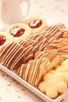 a plate full of cookies and pastries next to a cup of coffee