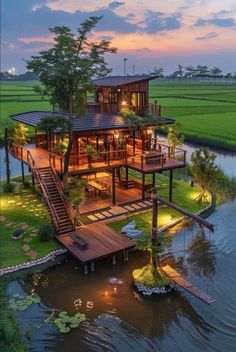 an aerial view of a house on stilts in the middle of water at dusk