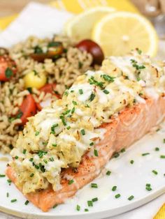 salmon and rice on a plate with lemon wedges