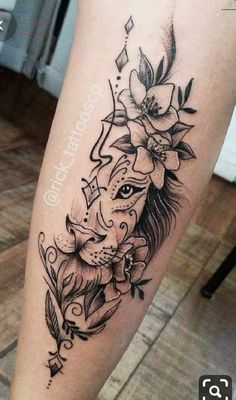 a woman's leg with an elephant and flower tattoo on the side of her leg