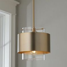 a light fixture hanging from the ceiling in a room with white walls and window sill