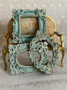 an ornate blue and gold frame sitting on top of a wooden table