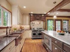 a large kitchen with an island counter and stainless steel appliances in the middle of it