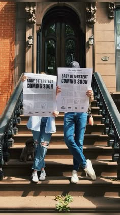 two people holding up signs on the steps