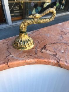 a faucet that is sitting on top of a marble counter in front of a store