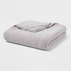 a light gray blanket folded on top of a white table