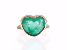 This ring is not for the faint of heart! Displayed is a large Colombian emerald heart solitaire ring in 14K gold. This gorgeous solitaire ring is bezel set in yellow gold and carries a full 6.10-carat emerald that will have you gazing at its mystic beauty. This large gem has minor imperfections as no natural emerald is flawless. This emerald is absolutely stunning and will have you captivated at first glance. This ring is one of a kind and made by our company in South Florida, USA. Setting Style Emerald Heart-shaped Anniversary Rings, Emerald Heart Shaped Anniversary Rings, Formal Heart Cut Emerald Ring, Fine Jewelry Heart Ring With Bezel Setting, Fine Jewelry Heart Cut Ring With Bezel Setting, Heart Cut Bezel Set Heart Ring, Heart Cut Rings With Bezel Setting, Heart-shaped Emerald Ring For Anniversary, Fine Jewelry Heart Cut Ring For May Birthstone