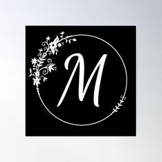 a black and white monogrammed letter m with flowers on the bottom, in a circle