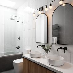 a bathroom with two sinks and mirrors on the wall