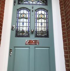 a green door with two stained glass windows