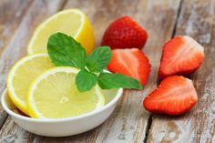 strawberries, lemons and strawberries in a bowl on a wooden table