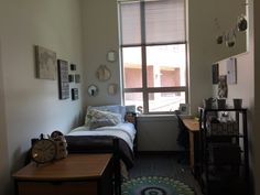 a bedroom with a bed, desk and window