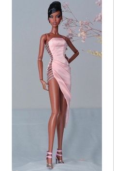 a barbie doll wearing a pink dress and high heeled sandals with flowers in the background