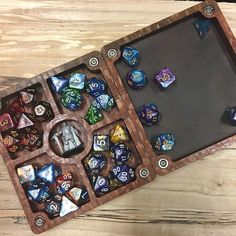 a wooden board game with dices and other items on top of it, sitting on a table