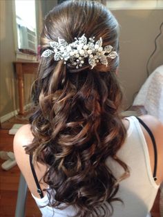 a woman with long brown hair wearing a flowered headpiece on top of her head