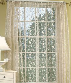 a bedroom with a bed, dresser and large window in it's center area