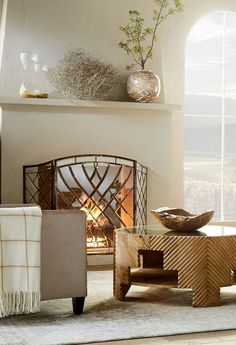 a living room filled with furniture and a fire place in front of a large window