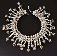 "This incredible collar necklace is unsigned, however, it is attributed to either Coppola e Toppo, Mimi D'N, or Hattie Carnegie. Whoever the designer, it is fabulous and done with incredible talent, artistry, and quality construction Look at the back side constructiongorgeous glass pearl bead strings are mounted onto a weft (like Coppola e Toppo) of glass pearls. The strings are made up of glass pearls, rhinestone rondelles, and rhinestone rondelle balls. There is some color wear to the gold pla Traditional White Jewelry For Evening, Traditional White Evening Jewelry, White Round Bridal Necklace For Evening, White Necklace With 17 Jewels For Celebration, Luxury Beaded Bridal Necklace For Wedding, Glamorous White Bridal Necklace Gift, Celebration White Bridal Necklace With 17 Jewels, Glamorous White Necklaces For Evening, White Beaded Bridal Necklace For Evening