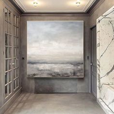 a large painting hanging on the wall in a hallway next to an open door and window