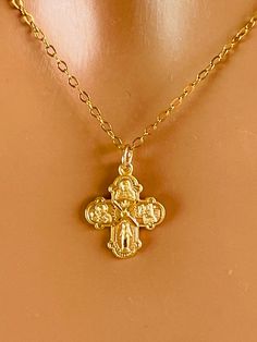 This is a dainty little gold four way cross charm necklace. This cute little cross is 14 karat gold over 925 sterling silver and hangs on a 14 karat gold filled chain. Spring clasp in back. Also available in 925 sterling silver, not shown. This small cross charm measures 15 X 13 mm and features Mary miraculous medal, Jesus Christ, Saint Christopher and Saint Joseph. Please be aware this is a very small charm. Chain is on a lovely shiny cable chain that sparkles with movement.  Model is wearing a Yellow Gold Charm Necklaces With Cross Pendant, Yellow Gold Cross Charm Necklace Tarnish Resistant, Gift 14k Gold Filled Cross Pendant Charm Necklace, Gold 14k Cross Pendant Charm Necklace, 14k Gold Cross Pendant Charm Necklace, Dainty Yellow Gold Cross Pendant Necklace, Yellow Gold Tarnish-resistant Cross Charm Necklace, Gold Cross Charm Necklaces, Gold Cross Charm Necklaces In 14k Gold Filled