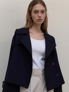 This is a clean and casual trench jacket by L’oiE that is made out of high quality and sturdy fabric. With unique design detail and trendy mood, you can style it for your refined and casual daily outfit.- Unique short length- Vent detail on the back and button detail- Modern and sophisticated look Navy Collared Outerwear For Work, Modern Collared Outerwear For Office, Navy Double-breasted Outerwear For Work, Chic Navy Outerwear With Lapel Collar, Navy Outerwear With Lapel Collar For Work, Navy Lapel Collar Outerwear For Office, Chic Navy Double-breasted Peacoat, Chic Peacoat With Pockets For Work, Navy Outerwear With Lapel Collar And Hidden Buttons