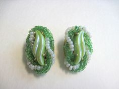 "Vintage Elsa Schiaparelli green art glass bead earrings circa 1930s.  Schiaparelli jewelry is highly prized and collectible.  These earrings are signed and are in lovely condition.  There is minor usage wear to the reverse side of the earrings but otherwise are in beautiful condition.  Measure approximately 1\" long.  Please review the photographs to see the condition issues up close.   The fixed shipping fee applies to US customers only. This item will ship via USPS insured mail. International customers should contact us, prior to purchase, to check on shipping availability and associated fee(s). Our goal is to have your experience with us be a positive one. Therefore it is important to us that you get a clear understanding of what you are considering before you purchase. All of our piec Green Handmade Earrings For Evening, Vintage Green Czech Glass Earrings, Vintage Green Beaded Earrings, Vintage Green Beaded Earrings With Round Beads, Schiaparelli Jewelry, Glass Bead Earrings, Elsa Schiaparelli, Jewelry Ads, French Fashion Designers