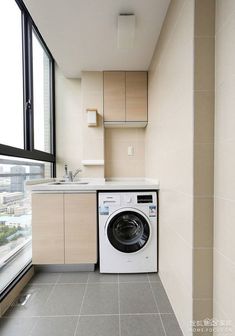 a washer and dryer in a small room with large windows overlooking the city