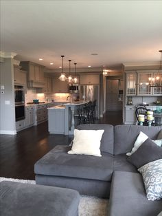 a living room filled with furniture next to a kitchen