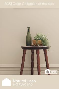 a wooden table with a vase on top of it next to a plant and potted plants