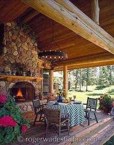 an outdoor dining area with table, chairs and fire place in the middle of it