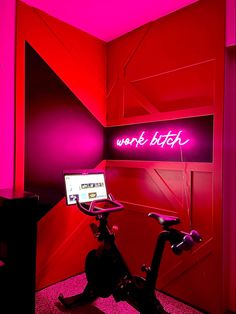 there is a bike in the room with neon lights on it and a laptop computer