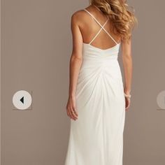 a woman in a white dress is looking at the back of her dress and has long blonde hair