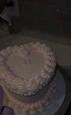 a white heart shaped cake sitting on top of a table