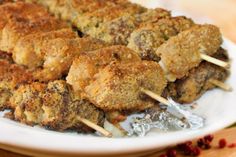 chicken skewers with toothpicks on a white plate