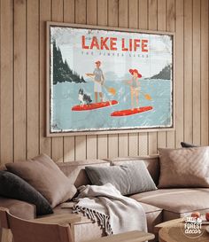 a living room with a couch, coffee table and poster on the wall that says lake life