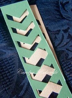 a green and white bookmark sitting on top of a blue cloth