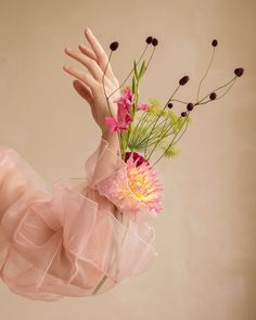 a woman's hand holding a bouquet of flowers