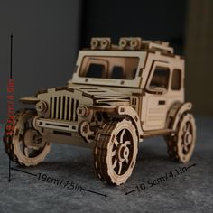 a wooden model of a jeep is shown on the floor, with measurements in front of it