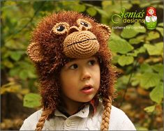 a young child wearing a monkey hat with braids on it's head and looking at the camera