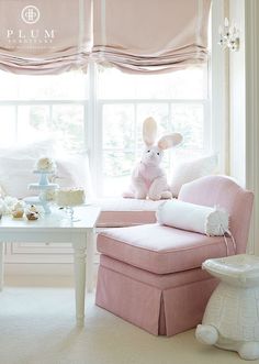 a pink chair in front of a window with a stuffed animal on top of it